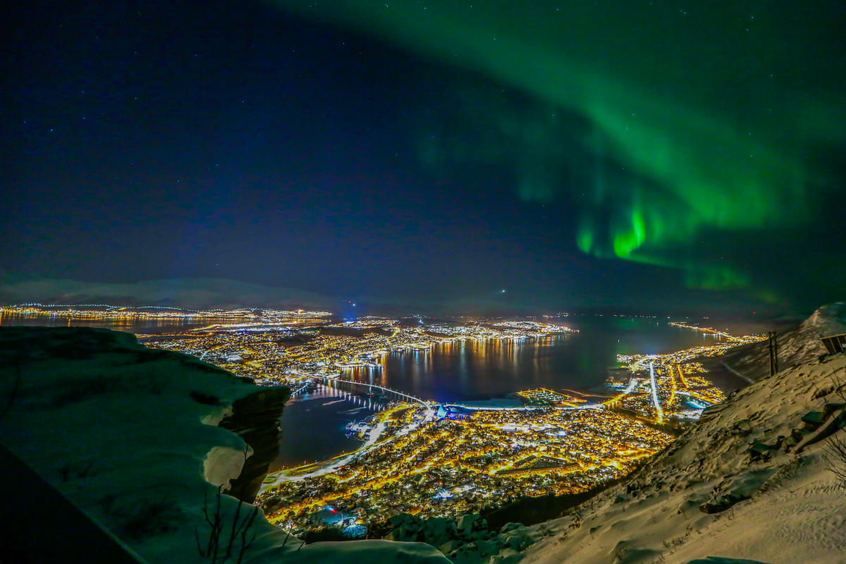 Tromso, Norway with Northern lights hovering above