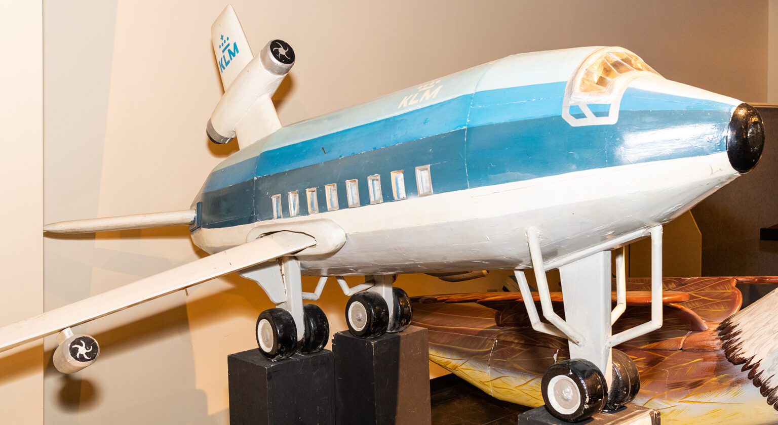 Hand-carved fantasy coffin shaped like a plane, crafted by Ghanaian artisans.